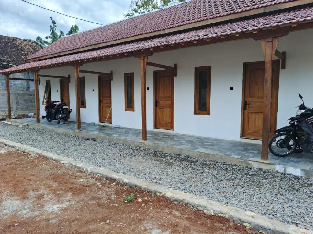 a house with two motorcycles parked in front of it at Alkache in Wonosari