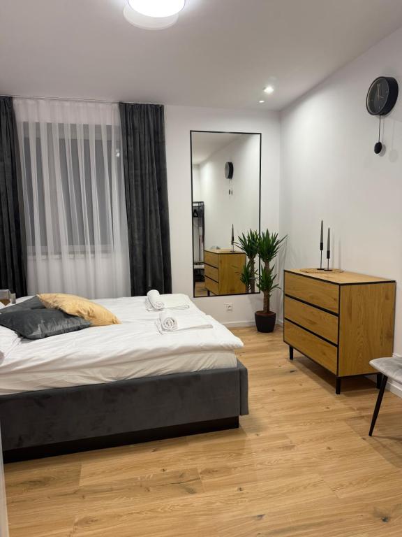 una camera da letto con un letto, un comò e uno specchio di MICKIEWICZ HOUSE Apartamenty a Wadowice