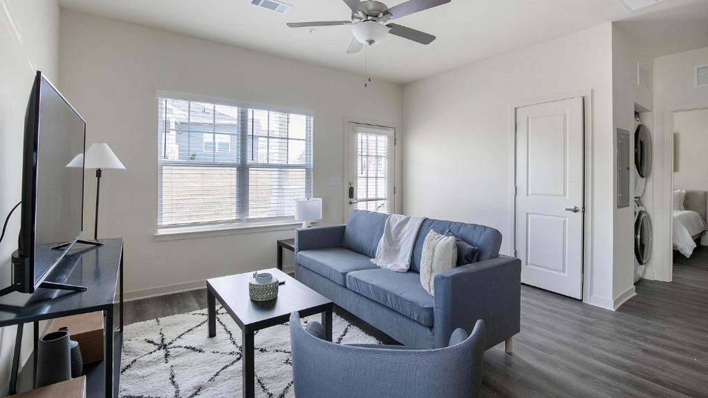 a living room with a blue couch and a table at Landing Beautiful 1BD in North Fort Worth in Fort Worth