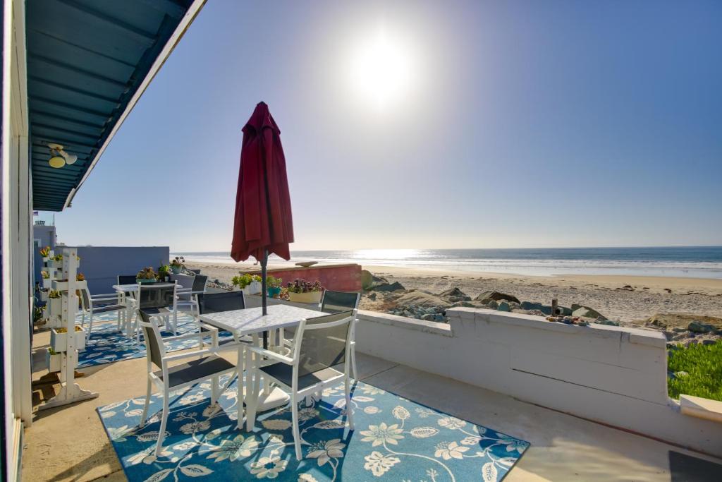 een patio met een tafel en stoelen en het strand bij Oceanfront Escape Steps to Imperial Beach! in Imperial Beach