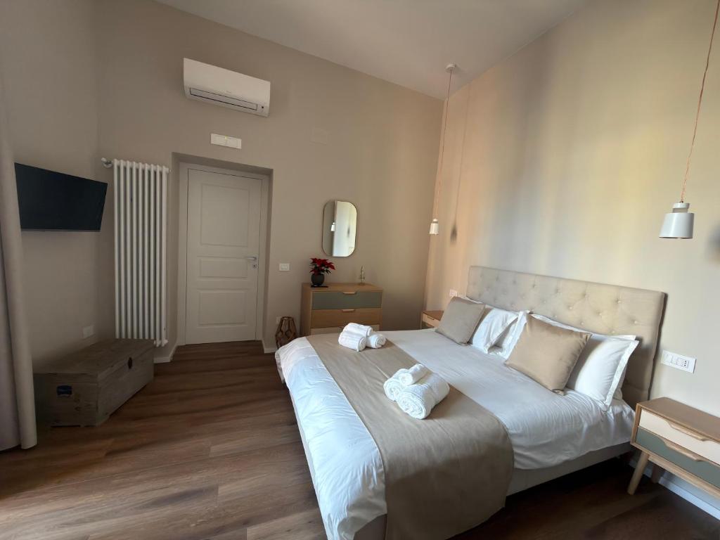 ein Schlafzimmer mit einem großen Bett mit weißen Laken und Kissen in der Unterkunft Domis Napoli in Neapel