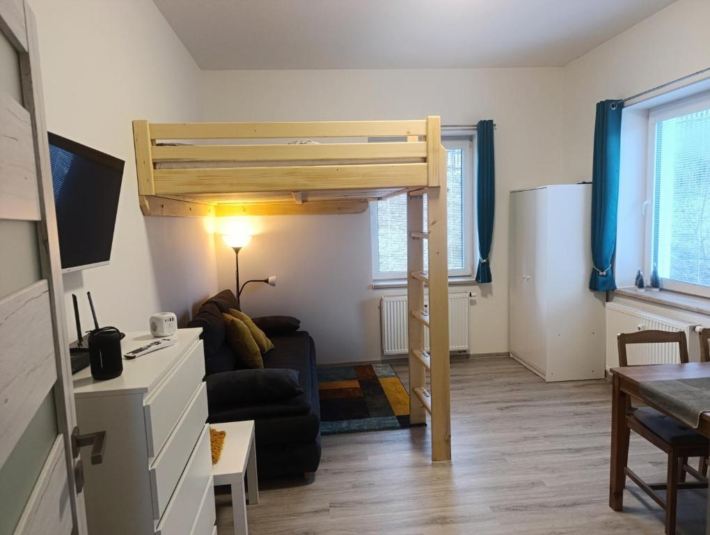een woonkamer met een hoogslaper en een bank bij Apartmán Denisa in Rokytnice nad Jizerou
