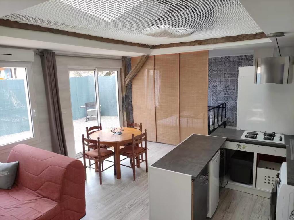 una cucina e un soggiorno con tavolo e sedie di L'atypique a Lignières