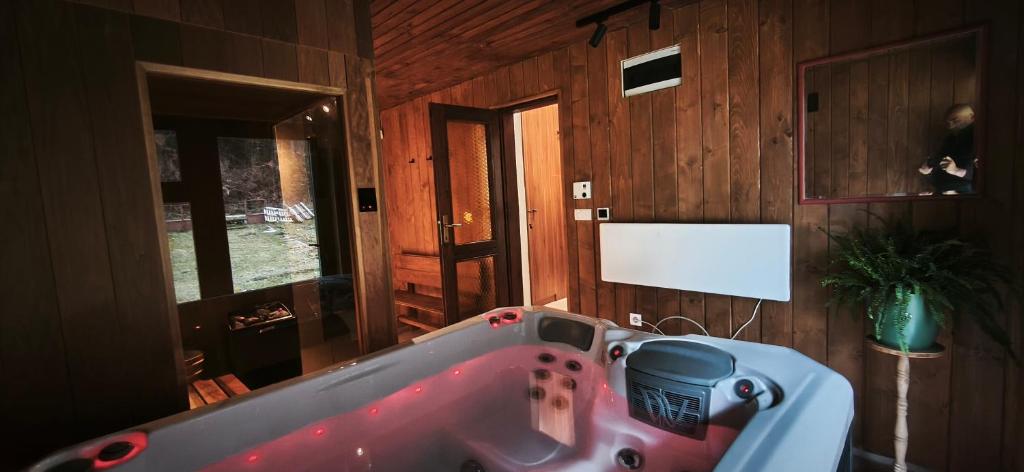 een bad in een kamer met een houten muur bij Wellness house Svjetlost in Jahorina