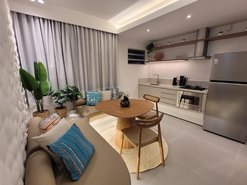 a living room with a couch and a table at Praia do Rosa Park Studio in Guarapari