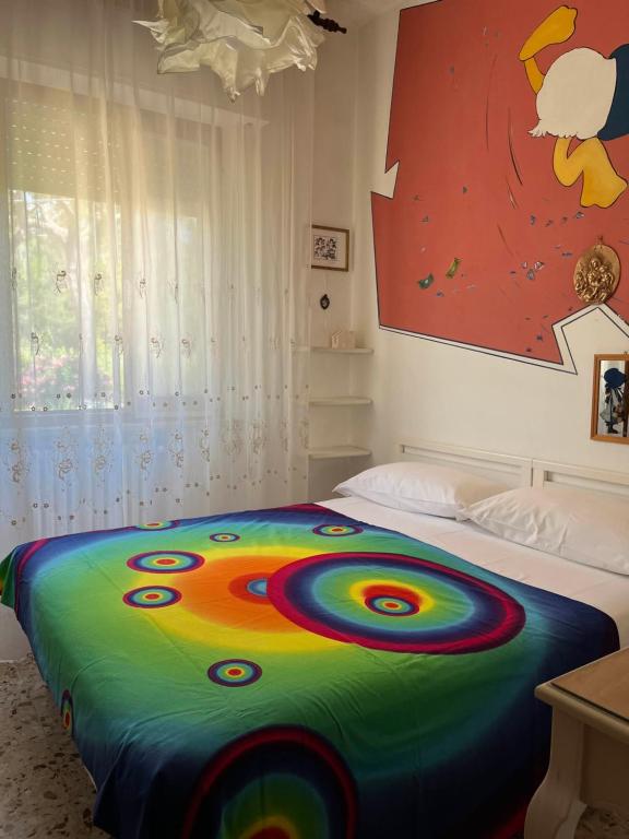 a bed with a colorful blanket on it in a bedroom at B&B Amurri Domenica in Grottammare