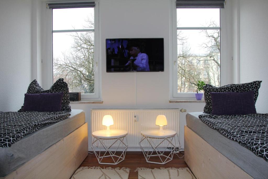a bedroom with two beds and two tables with lamps at Pension963 in Crimmitschau