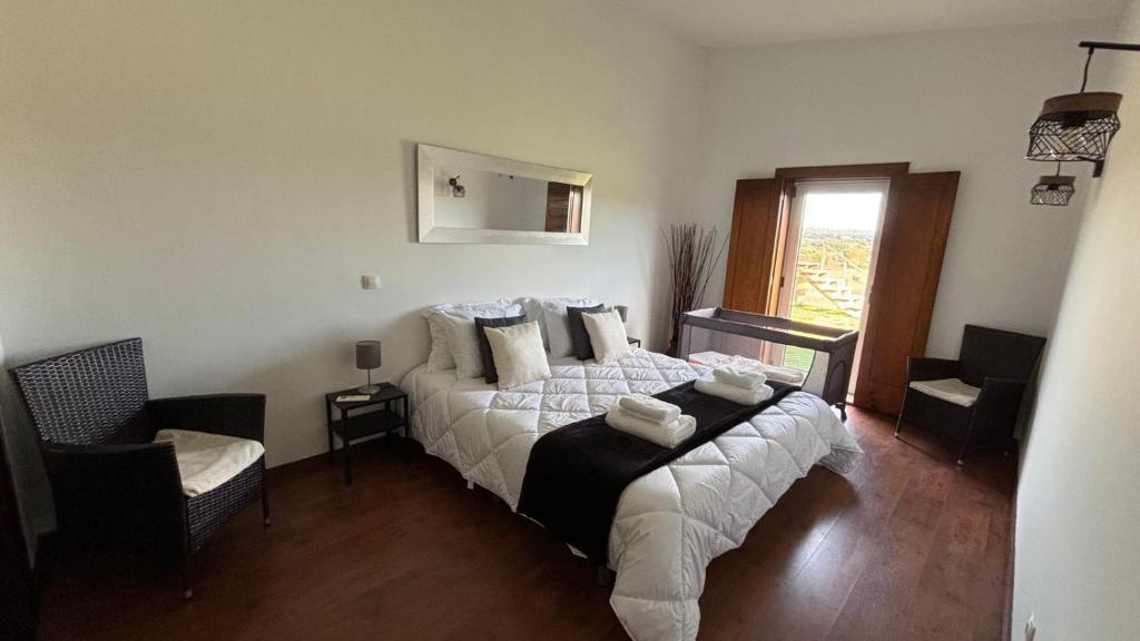 een slaapkamer met een bed, een stoel en een raam bij Pouso Du'Vagar in Cuba