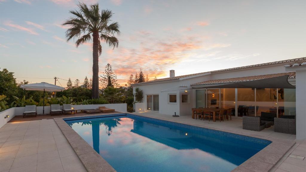 una piscina in un cortile con una casa di Casa dos Pelargónios a Luz