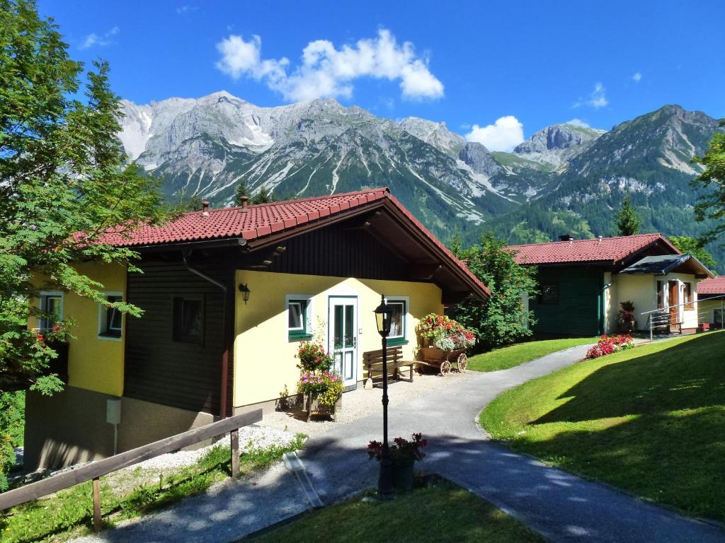a house with mountains in the background at Ramsauer Sonnenalm in Ramsau am Dachstein