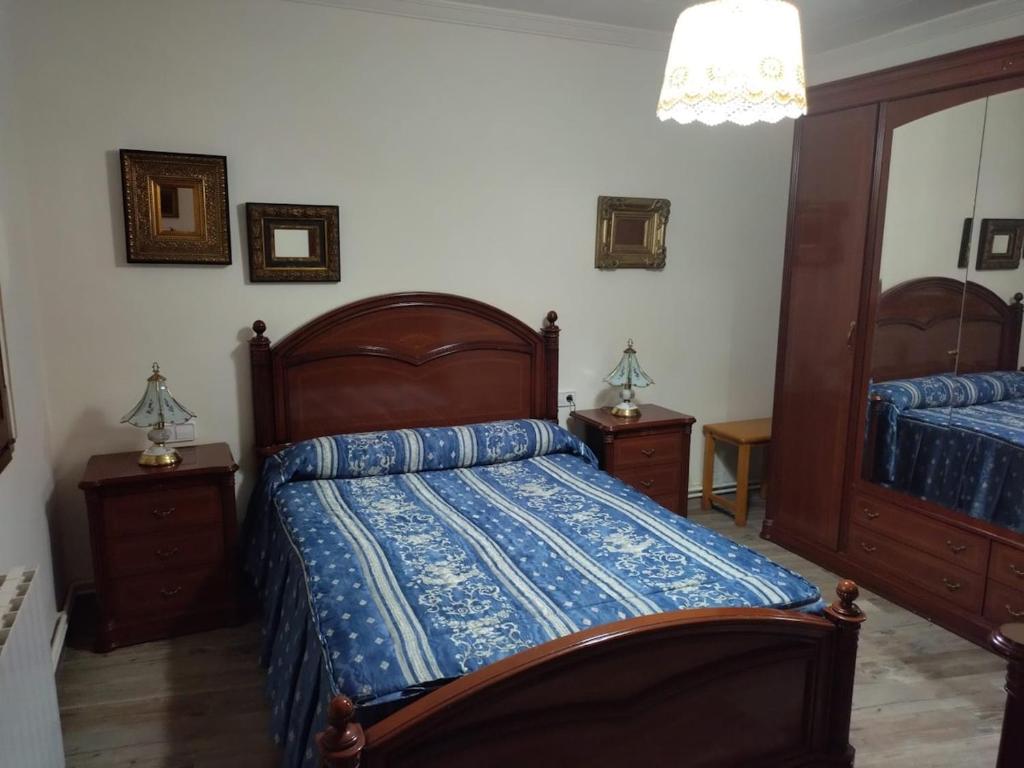 een slaapkamer met een bed met een blauw dekbed bij Ramon del Xalet in Ibars de Noguera