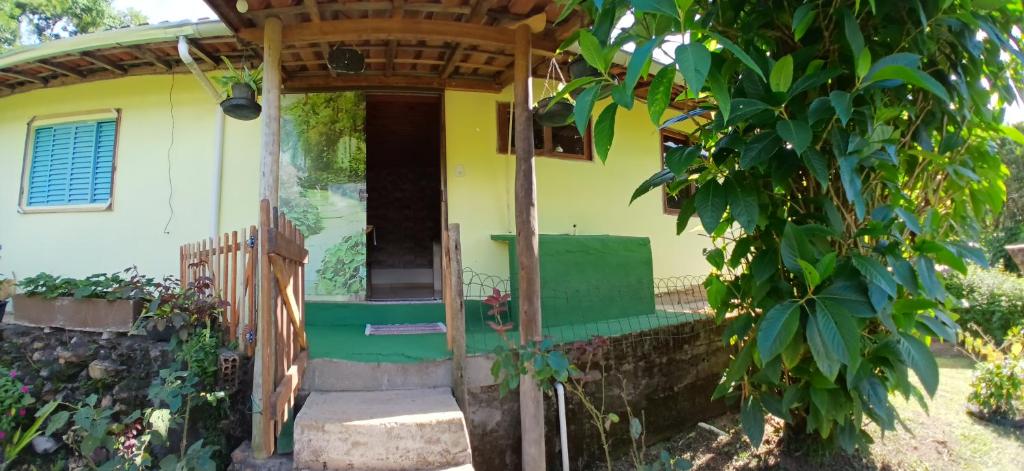 een klein geel huis met een groene deur bij Casa Amarela in Bocaina de Minas