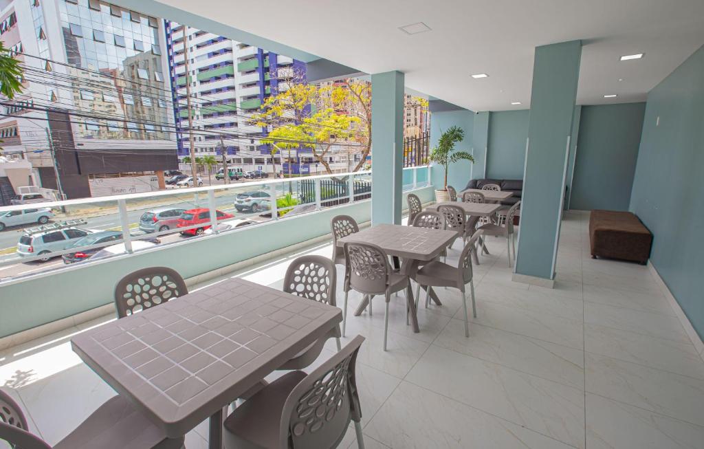 a restaurant with tables and chairs and a view of a city at Pousada Estrela Dourada in João Pessoa
