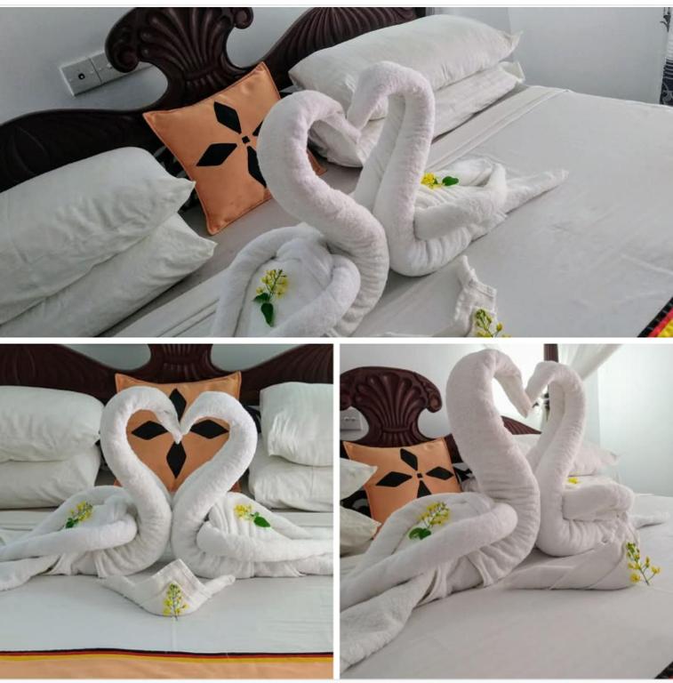 two swans made out of towels on a bed at Lucky Prince Villa & Ayurveda Wellness in Aluthgama