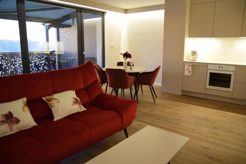 een woonkamer met een rode bank en een tafel bij Apartmány Žermanice in Horní Soběšovice