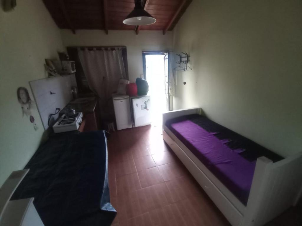 een slaapkamer met een paars bed in een kamer bij Mono Julian in Quequén
