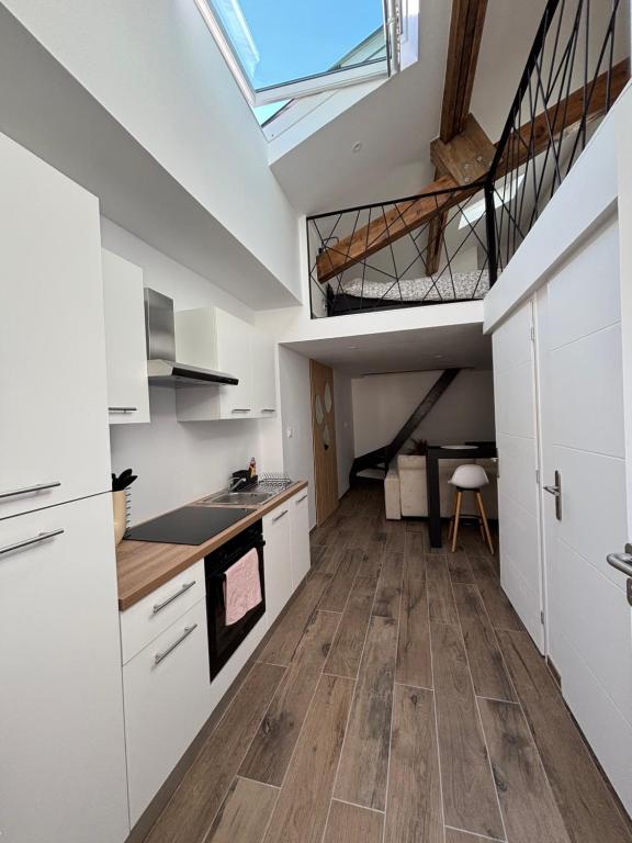 een keuken met witte kasten en een loft bij Studio in Amblagnieu