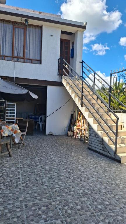 a house with a staircase leading to a patio at Cabaña el Rincon Del Lago in Paipa
