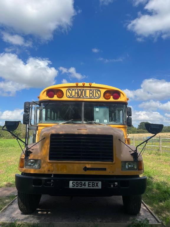 an old yellow school bus parked in a field at Camp Bonnie in Kent