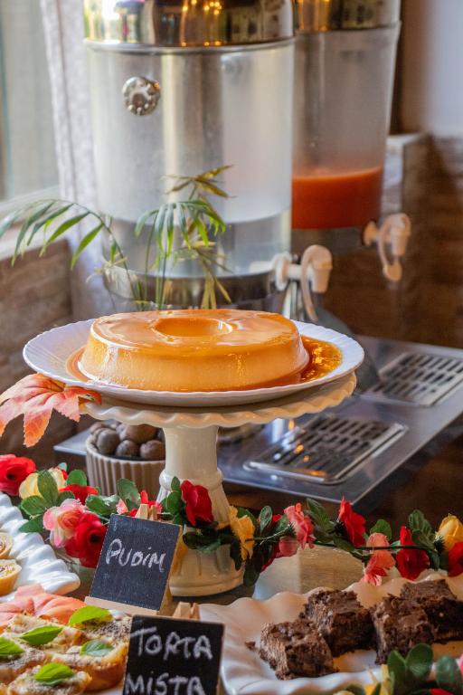 a cake on a plate on a table with other desserts at Pousada da Leide in Fernando de Noronha