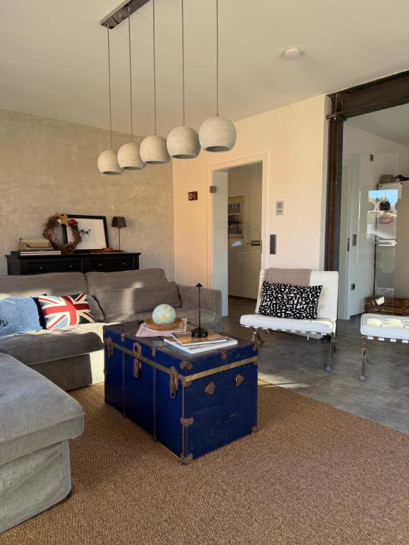 een woonkamer met een blauwe koffer in het midden bij Eifeeloft - Eifel erleben in Neroth