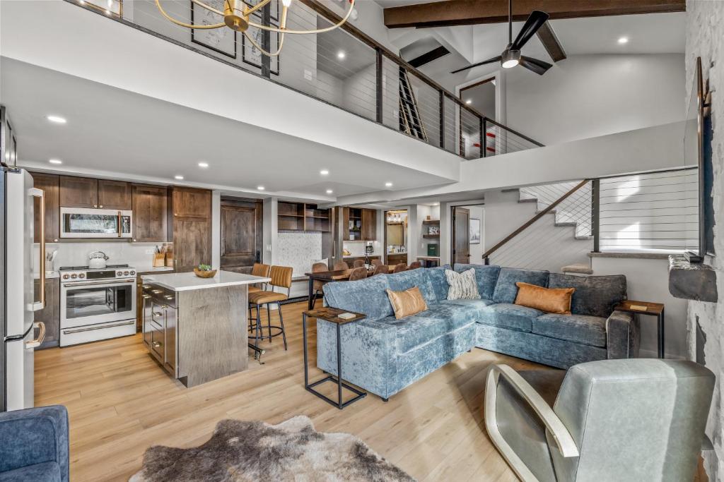 an open kitchen and living room with a blue couch at Bear Claw 402 - Premier Ski-in Ski-out & Winter Shuttle! Renovated 2025! in Steamboat Springs