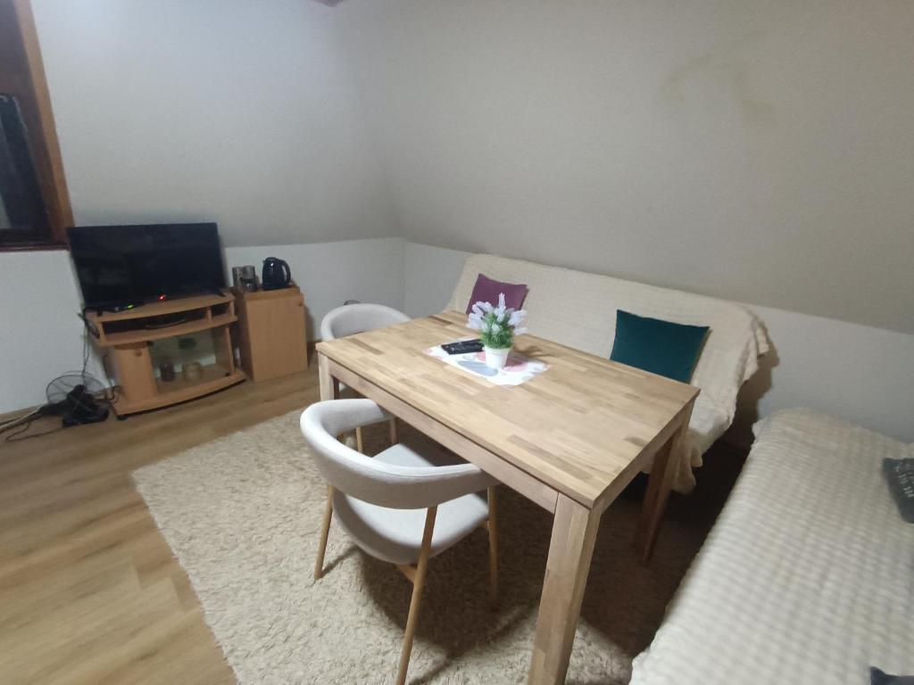 una camera con un tavolo in legno con due sedie e un letto di Vlasic Relax a Vlasic