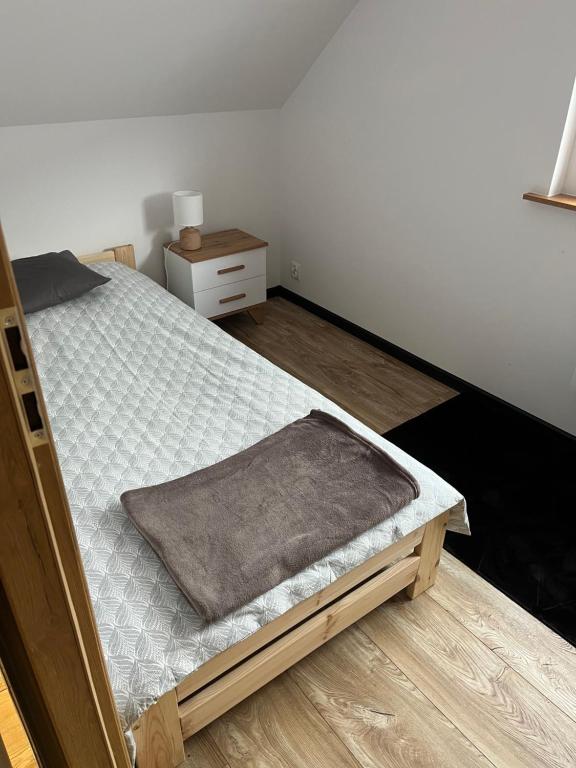 een slaapkamer met een bed en een nachtkastje bij Nest Haus in Ludwikowice Kłodzkie