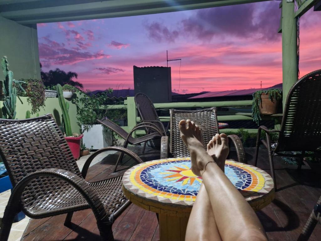 een persoon die op een terras ligt met zijn voeten op een tafel bij Joaquina 433 - Pousada Floripa in Florianópolis