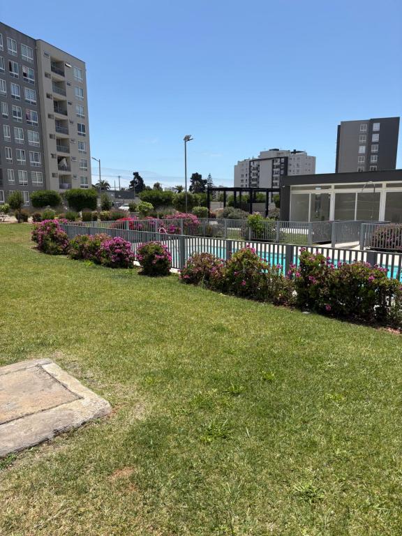een park met een hek en bloemen en gebouwen bij Comodo y cercano a la playa in Coquimbo