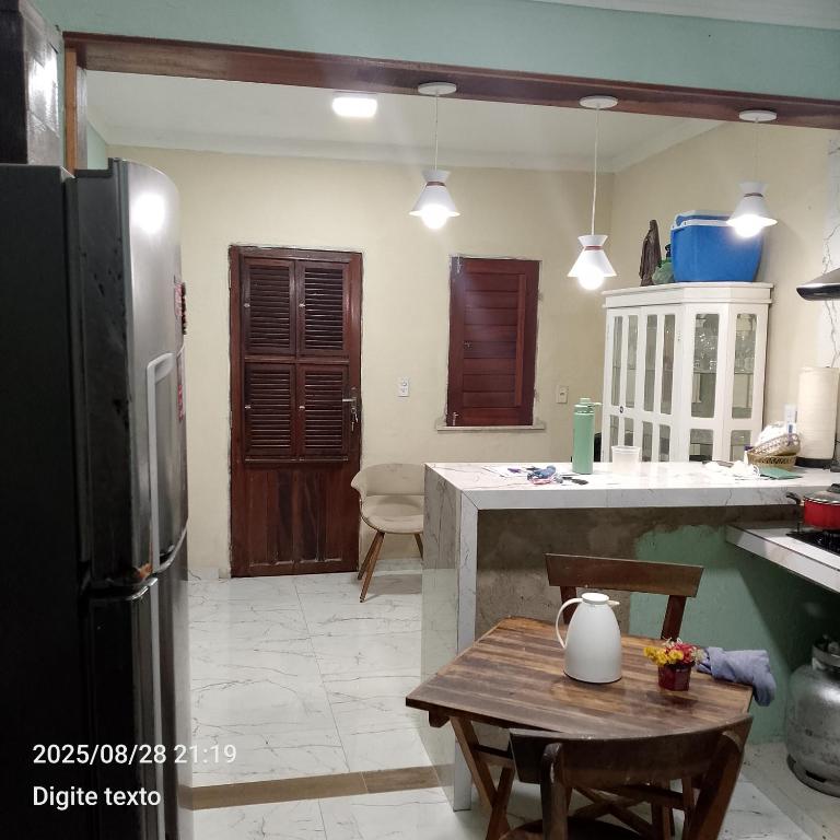 a kitchen with a refrigerator and a table in it at Aconchego particular in Guaramiranga
