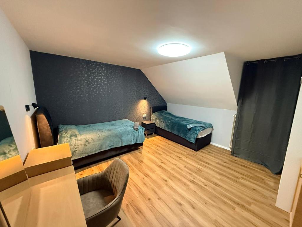 ein Zimmer mit 2 Betten und einem Stuhl darin in der Unterkunft Pension bei Laura in Schwerte