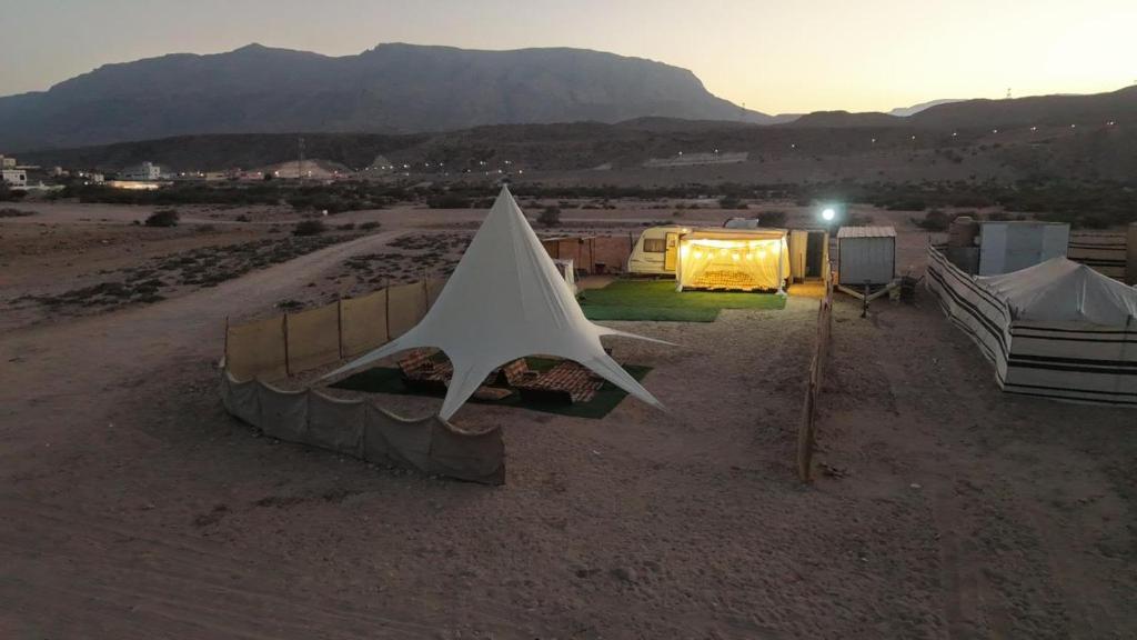 een groep tenten in de woestijn bij zonsondergang bij مخيم الحياة in Ḑibāb