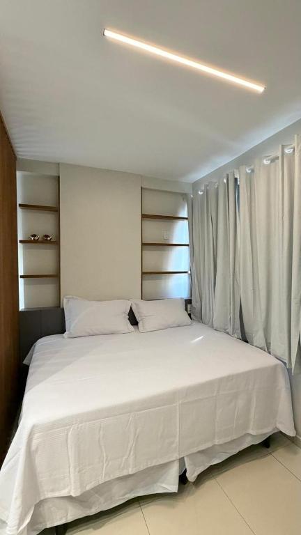 a large white bed in a room with a window at Studio moderno Alu lounge 103 in São Luís