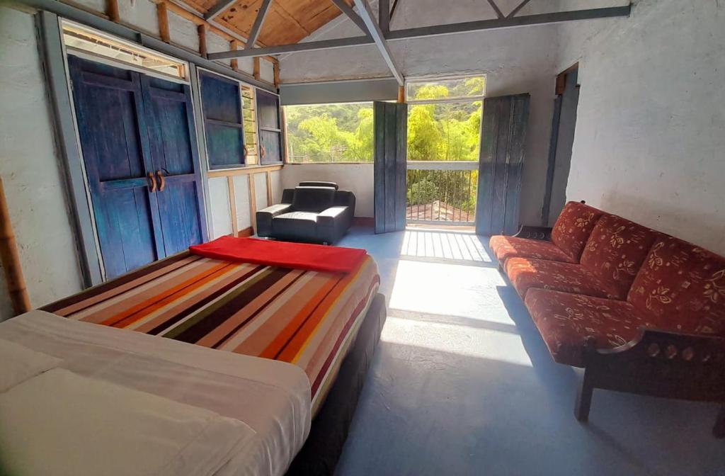 En eller flere senge i et værelse på Hostal Casa Pijao