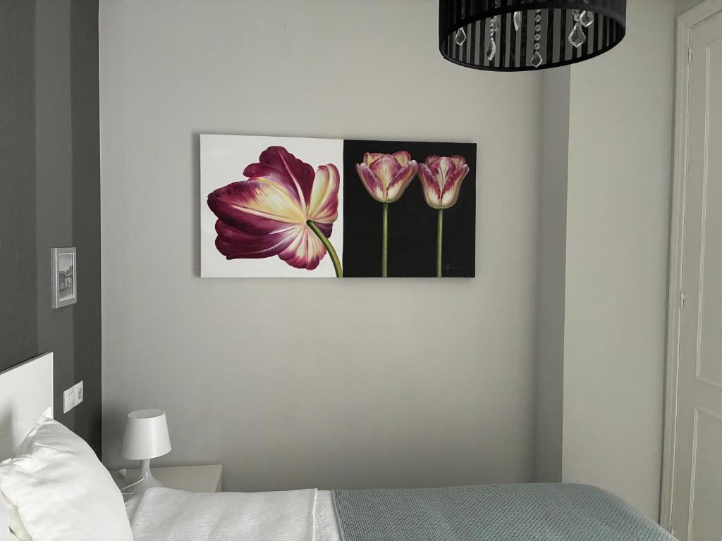 a bedroom with two pink flowers on the wall at Apartamento Castillo San Marcos in El Puerto de Santa María