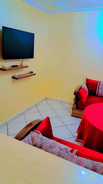 a living room with a red couch and a flat screen tv at le riffe in Nador