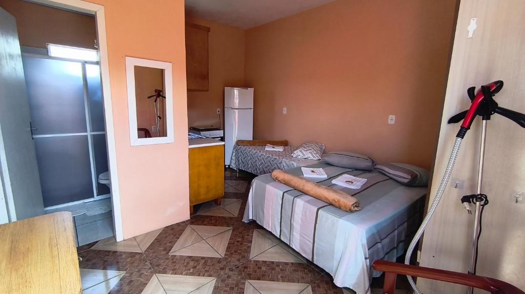 ein kleines Zimmer mit einem Bett und einer Küche in der Unterkunft Pousada da Dinda - Casa Familiar in São Gabriel