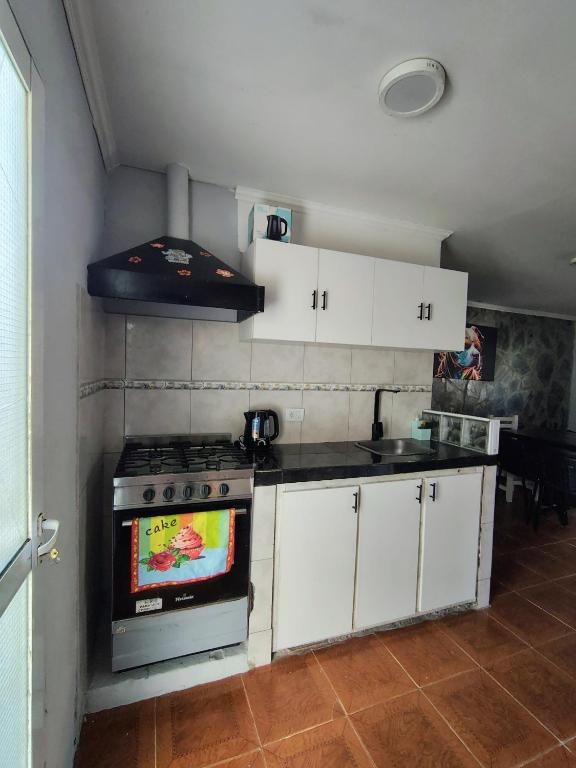 a kitchen with a stove and white cabinets at El descanso in Necochea
