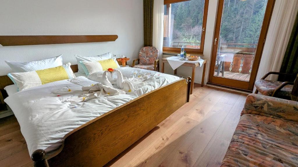 een slaapkamer met een groot bed met witte lakens bij Decker's Bio Hotel zum Lamm in Baiersbronn