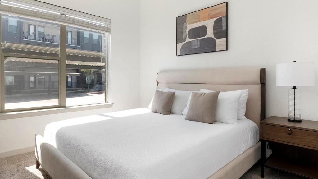 una camera da letto con un letto bianco e una finestra di Landing Apartments - Cedar Lakes a Duncanville