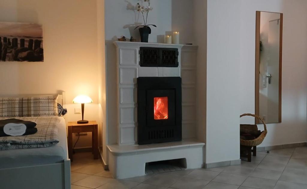 een open haard in een woonkamer met een bank bij Fewo Seestern in Bremerhaven