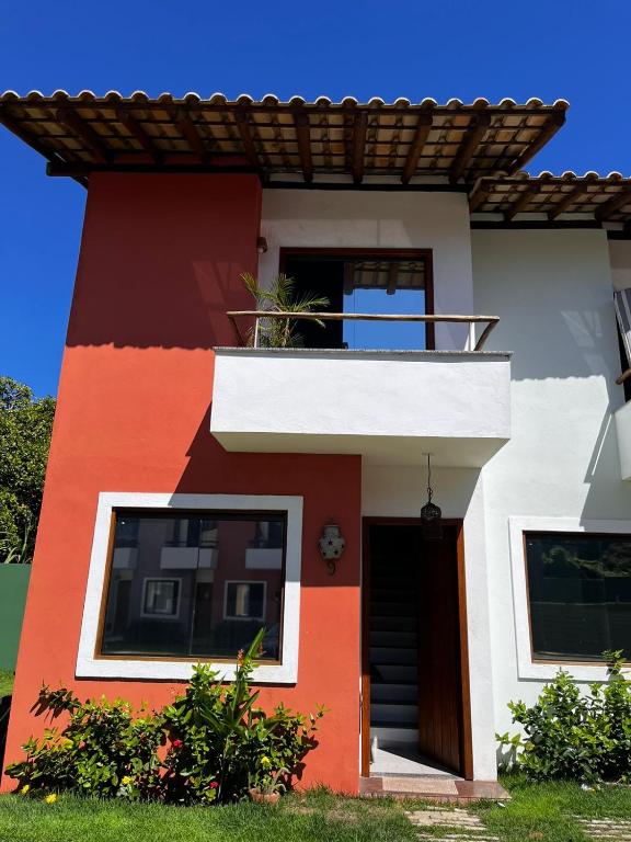 a red and white house with a balcony at Casa Vila São Miguel in Itacaré