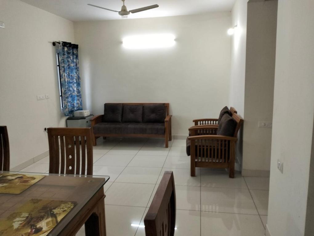 a living room with a couch and chairs at Elegant Stay at Bangalore International Airport in Bangalore