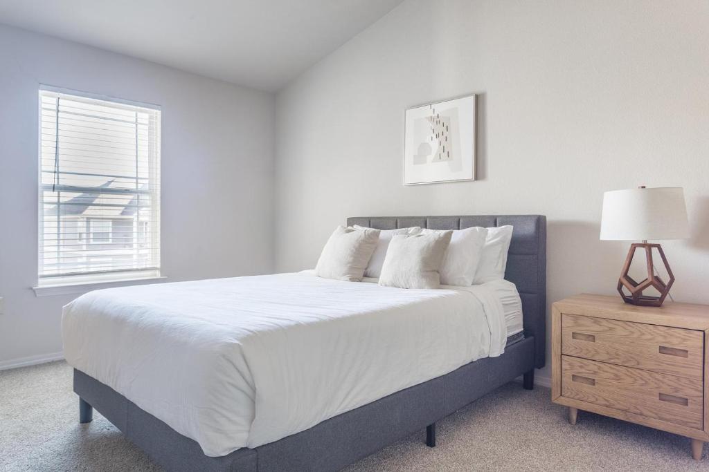 een slaapkamer met een bed, een nachtkastje en een raam bij Landing Stylish 1BD Courtyard Pool in Broken Arrow