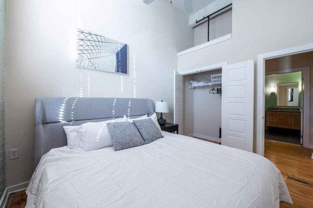 ein Schlafzimmer mit einem weißen Bett mit blauem Kopfteil in der Unterkunft Landing Stylish 1BD Courtyard Gym in Petersburg