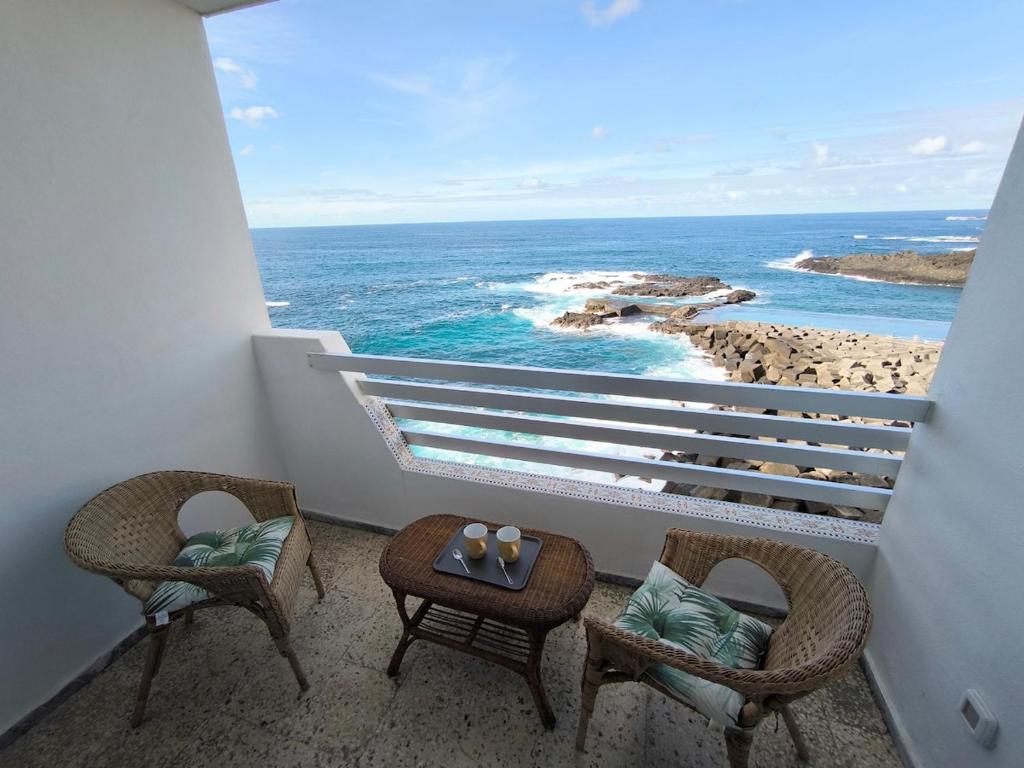 een balkon met stoelen en uitzicht op de oceaan bij Looking at the ocean sunset in Puerto de la Madera
