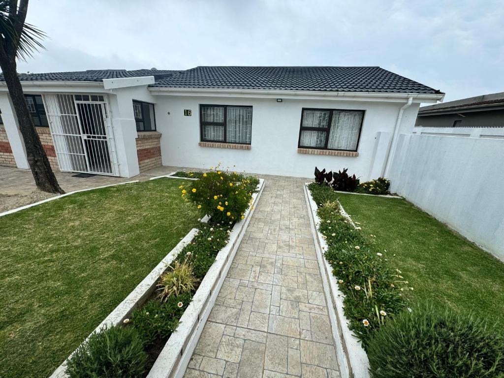 een huis met een stenen loopbrug voor een tuin bij Da Silva Residence in George