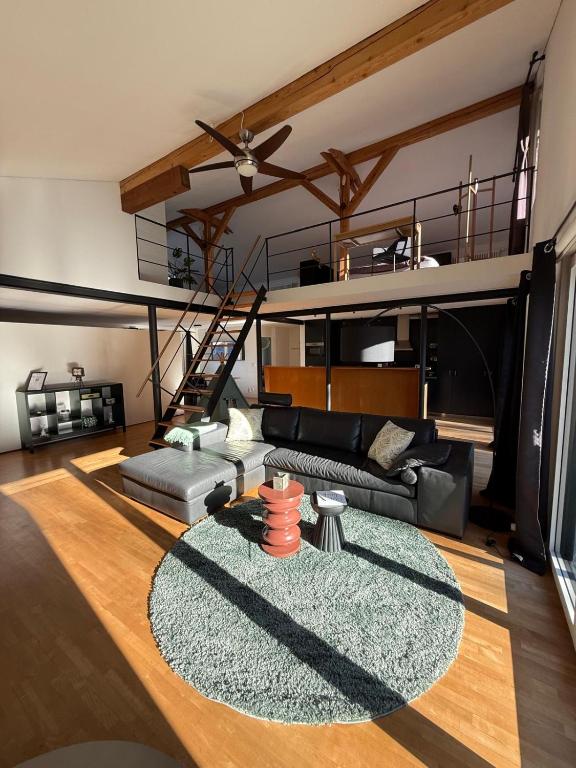 ein Wohnzimmer mit Sofa und eine Galerie in der Unterkunft LaVida Star Alpine Hideaway Thun, Sauna, free parking in Blumenstein