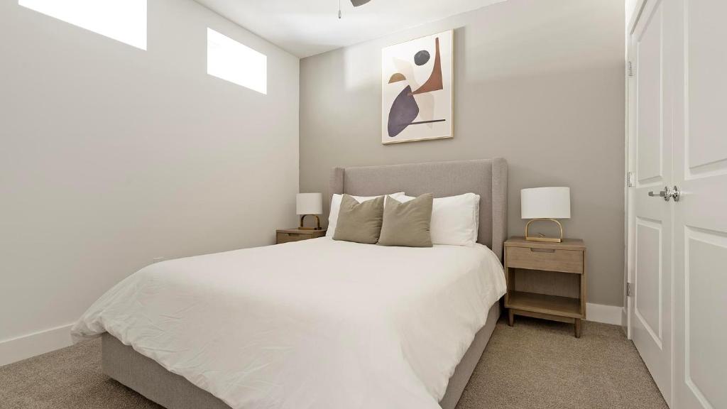 una camera da letto bianca con un letto bianco e due lampade di Landing Chic 1BD Pool Gym a Black Horse Run